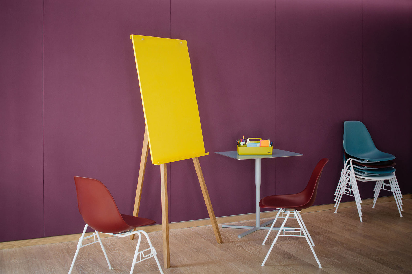 gelbes Flipchart mi Beinen aus Eichenholz vor einer lilafarbenen Wand