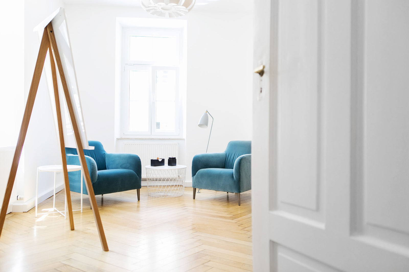 weißes Flipchart mit Beinen aus Eichenholz in einem Raum für Coachings